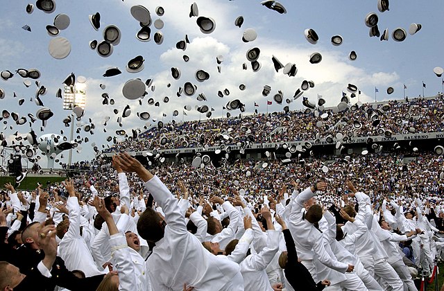Newly commissioned U.S. Navy and Marine Corps officers celebrate their new positions by throwing their midshipmen covers into the air as part of the U