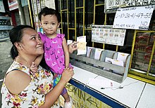 A woman place her bet on the Ultra Lotto 6/58. Ultra Lotto 6-58 bettor PH.jpg