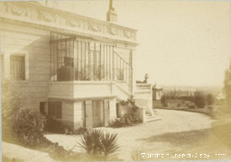Altes Foto einer Villa mit geformter Fassade und Veranda.