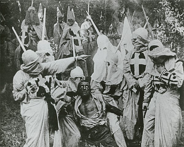 Hooded Klansmen catch "Gus", portrayed in blackface by Long, in The Birth of a Nation (1915)