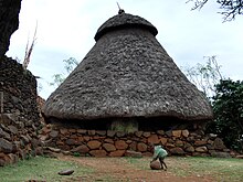 Boy playing ball in front of a Konso stone house Boy playing in Konso village.JPG