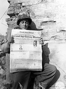 A U.S. soldier reads the Duluth News Tribune while serving in Italy, 26 January 1945 Cpl. Alfred B. Bergher, 15 E. 8th St., Duluth, Minnesota, reads a copy of his hometown newspaper. 26 January, 1945. (52612481919).jpg
