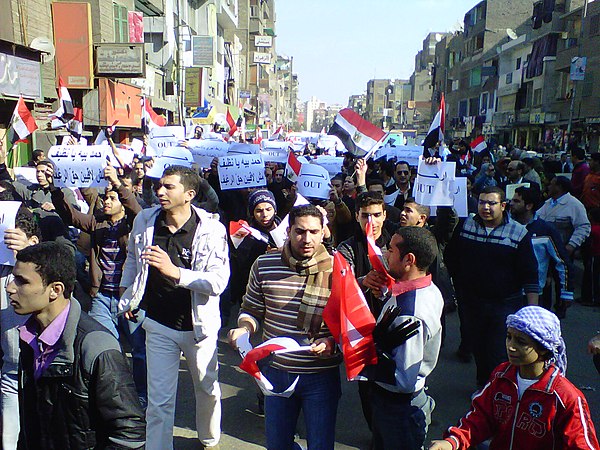Egypt, 25 January 2011: marchers in Cairo with 'OUT' signs on the 'Day of Anger' against President Mubarak. On 11 February he left office.