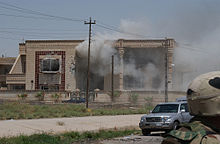 Smoke pours from Qusay and Uday Hussein's safehouse during the raid after it was hit by a TOW missile Defense.gov News Photo 030722-A-3450H-034.jpg