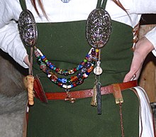 Typical jewellery worn by women of the Karls and Jarls: ornamented silver brooches, coloured glass-beads and amulets Eiriksstadir - Wikingerschmuck.jpg