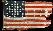 Photograph of a faded and torn United States flag