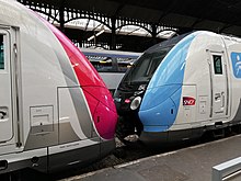 Twee Z 50000 treinstellen in het station Paris-Saint-Lazare, links in Carmillon-kleurstelling, rechts in Île-de-France Mobilités-kleurstelling.