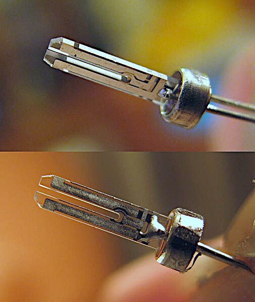 Quartz crystal resonator from a modern quartz watch, formed in the shape of a tuning fork. It vibrates at 32,768 Hz, in the ultrasonic range.