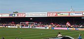 One of the stands of the Bootham Crescent association football ground, with supporters waving flags and a grass field below