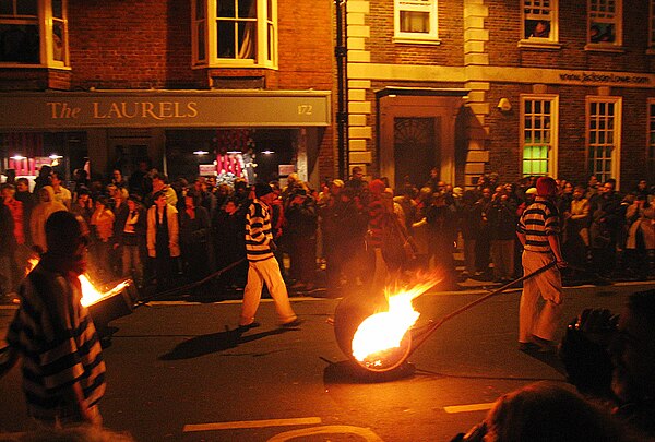 Members of the Cliffe Bonfire Society drag burning tar barrels through the streets of Lewes as part of their Bonfire Night celebrations.