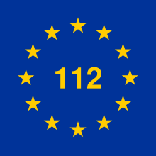 12 gelbe Stern im Kreis, in der Mitte „112“ im gleichen Gelb, blauer Hintergrund
