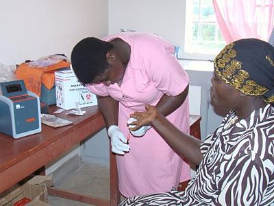 Measuring an HIV patient's CD4 count at the Kyabugimbi Health Center in Uganda Midwife draws blood to establish HIV patients CD4 count (7242176744).jpg