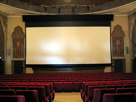 Film audiences are typically seated in comfortable chairs arranged in close rows before a projection screen. Norway (2005)