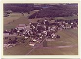Flyfoto av Nøtterøy sentrum, trolig fra rundt 1970, med Wilhelmsenhallen bak Borgheim ungdomsskole litt til venstre for midt i bildet og med fylkesvei 308 Tinghaug helt til venstre. Foto: Widerøe/Vestfoldmuseene
