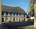 Wohnstallhaus, zwei Seitengebäude, Scheune und Wassertrog eines Vierseithofes