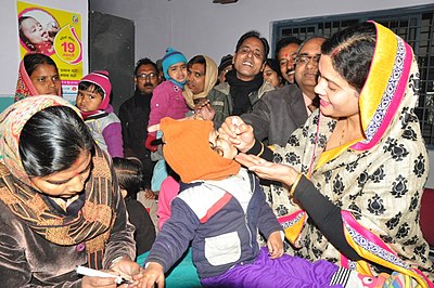 Large group of parents getting young children vaccined against polio via eye drops