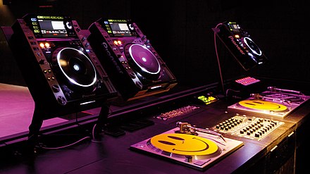 DJ workplace in a nightclub, consisting of three CDJs (top), three turntables for vinyl records and a DJ mixer