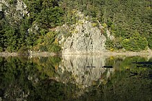 Fotografie ukazuje skálů na území rezervace pořízenou z druhého břehu řeky Otavy