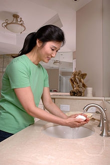 A woman washes her hands with soap and water. Woman washing hands.jpg