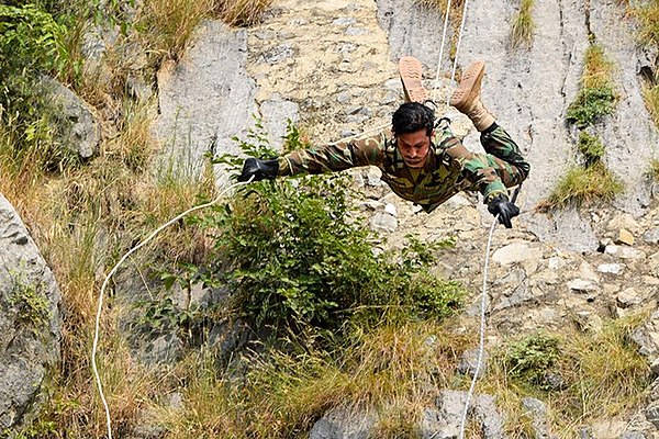 An Army SSG specialist, in U.S. Woodland uniform, performing the Mountain warfare course in a demonstration being performed for the Russian Spetnaz in