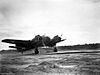 Twin-engined military aircraft landing on a runway