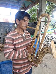 Musician Agustinus Sasundu of Sangihe, with a bamboo wind instrument