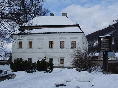 Vista de la casa pairal, on es pot veure a la dreta un cartell que indica que és un edifici protegit