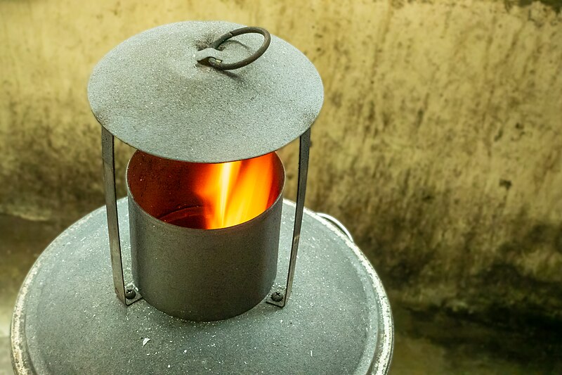 File:Burning joss paper flame in the burning bucket chimney close-up.jpg
