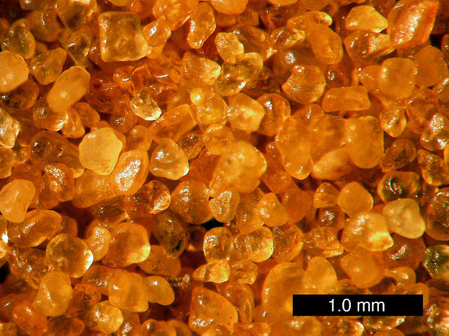 Sand from Coral Pink Sand Dunes State Park, Utah. These are grains of quartz with a hematite coating providing the orange color.