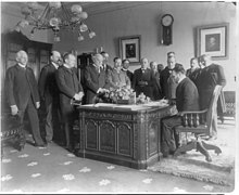Secretary of State John Hay signing a treaty of peace with Spain at the White House Exchange of the ratifications of the treaty of peace with Spain, made in the President's office, White House, Secretary of State John Hay signing LCCN2005688549.jpg