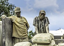 A father and a son in Goma, Congo, in 2017. Cement can cause significant harm to skin. Father and son loading and unloading cement in Goma, Congo.jpg