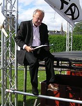 Galloway signing an asylum seekers petition, sitting on the edge of the StWC stage at the 2005 Make Poverty History rally. George Galloway MPH Rally.jpg