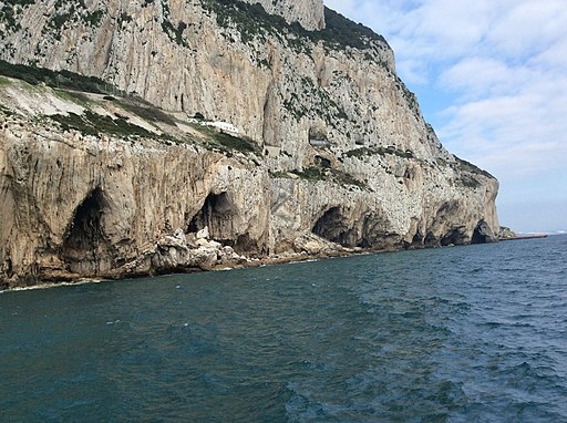 Blick nordwestwärts auf die Ostküste des Gibraltarfelsens mit Bennett's Cave (erster Felsbogen von links), Gorham-Höhle (darüber das Museum), Boat Hoist. Gorham's Cave Complex