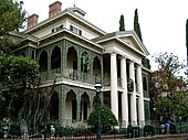 Атракционът Haunted Mansion в Disneyland, състоящ се от сграда и фасада отпред, като по-голямата част от маршрута е извън парка в свързани сгради.