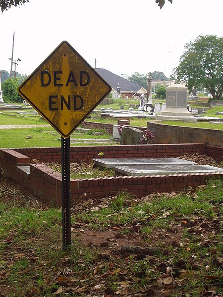 A cemetery with a "Dead End" sign, creating a play on words
