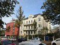 Apartment house in open development with front garden and remains of the enclosure