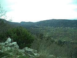 Изглед към Конавленското поле и селото в далечината през 2016 г.