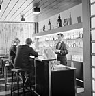A bartender serving customers at a bar in Jyväskylä, Finland, 1961