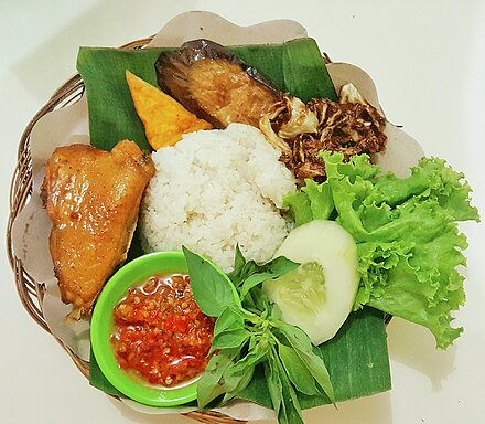 Lalab of cucumber, lettuce and lemon basil, with fried eggplant, cabbage, tofu and sambal, as part of ayam goreng meal.