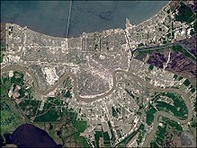 La Nouvelle-Orléans (au centre, vue de satellite) suit un méandre du fleuve Mississippi (au sud), d'où son surnom The Crescent City (la ville croissant). Le lac Pontchartrain est au nord.