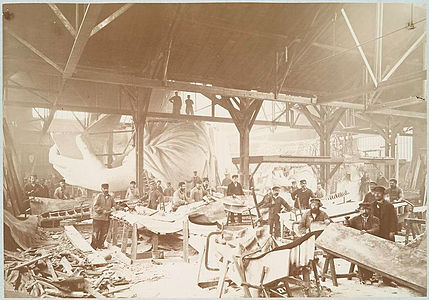 Men in a workshop hammering sheets of copper for the constr .... jpg