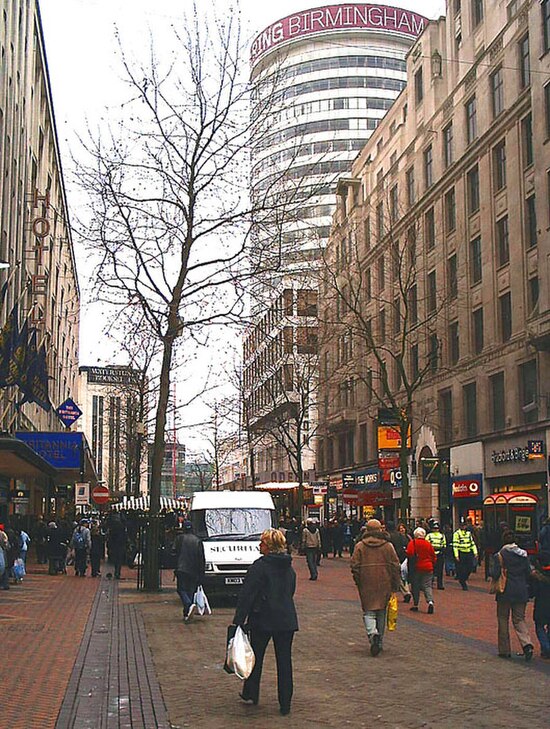 New Street in central Birmingham facing the cylindrical Rotunda. Visible on the right are the sign and doorway of The Yard of Ale; the premises former