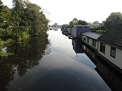photo d'un canal bordé à gauche d'arbres et à droite de maisons