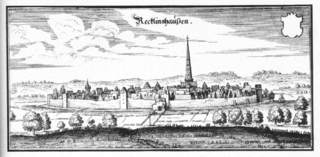 Meadows surround a fortified city, protected by thick walls, artillery towers, and a wide moat. The countryside around the city was flat, giving the inhabitants of the city, and the soldiers on its walls, an advantage of height. A church spire towers over the city and dominates the landscape.