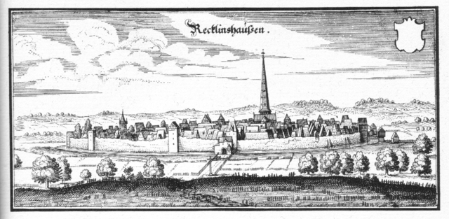 Meadows surround a fortified city, protected by thick walls, artillery towers, and a wide moat. The countryside around the city was flat, giving the inhabitants of the city, and the soldiers on its walls, an advantage of height. A church spire towers over the city and dominates the landscape.