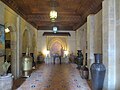 Interior of an elegant Riad, with fountain under a decorated arch, and elaborate carved wooden ceiling