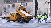 Workers spreading salt from a salt truck for deicing the road Salt truck Milwaukee.jpg