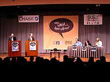 A recording of radio panel show Wait Wait... Don't Tell Me!, featuring, from left, announcer and scorekeeper Carl Kasell; host Peter Sagal; and panelists Adam Felber, Roxanne Roberts and Keegan-Michael Key before a live audience. Wait Wait... Don't Tell Me! Live Taping.jpg