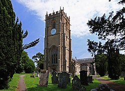 A church tower with churchyard and headstones in the foreground