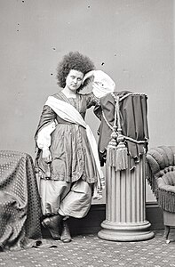 alternative1=Photographie d'une jeune femme debout aux longs cheveux crépus.